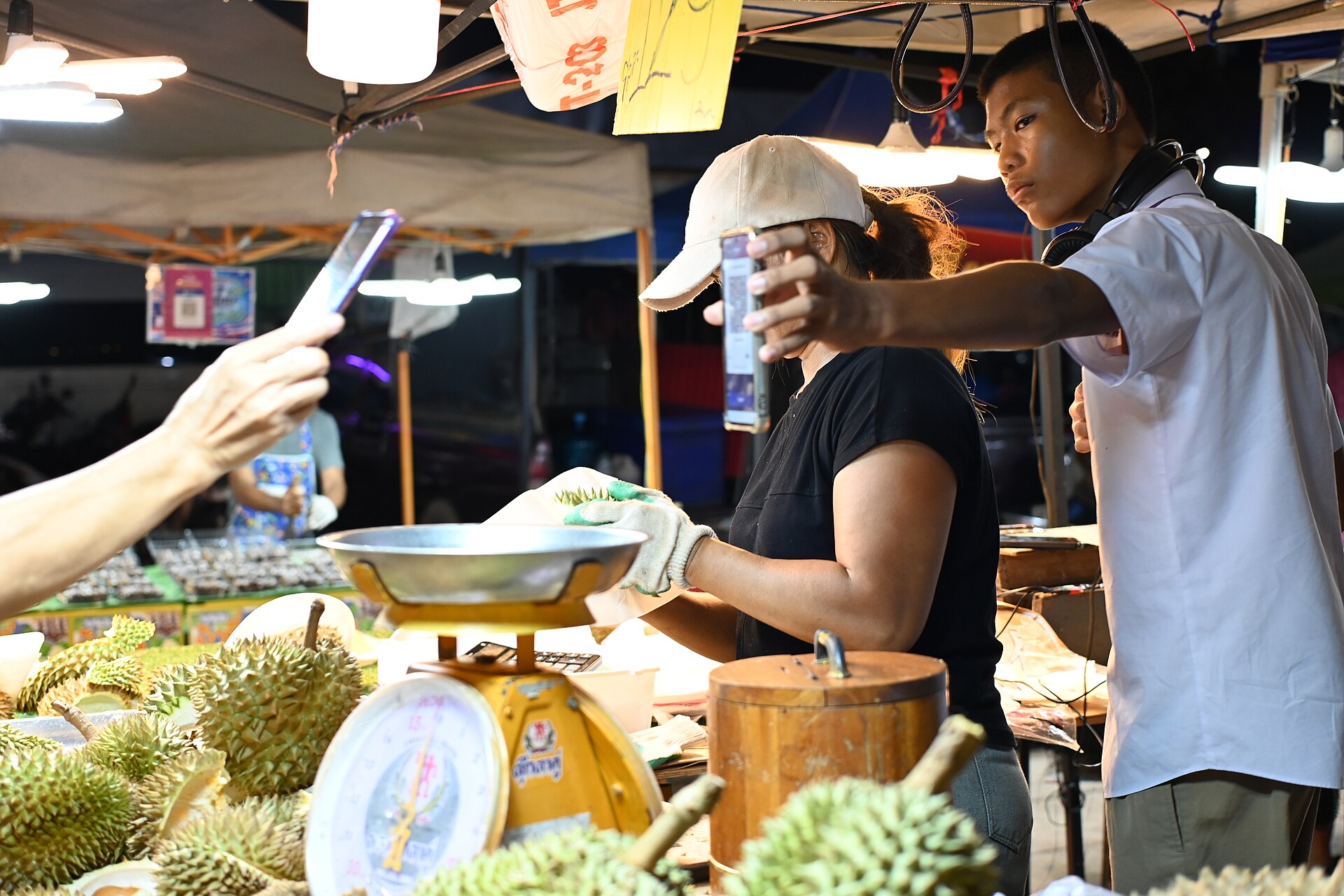 Pembeli memindai kode QR dengan ponsel di lapak pasar malam